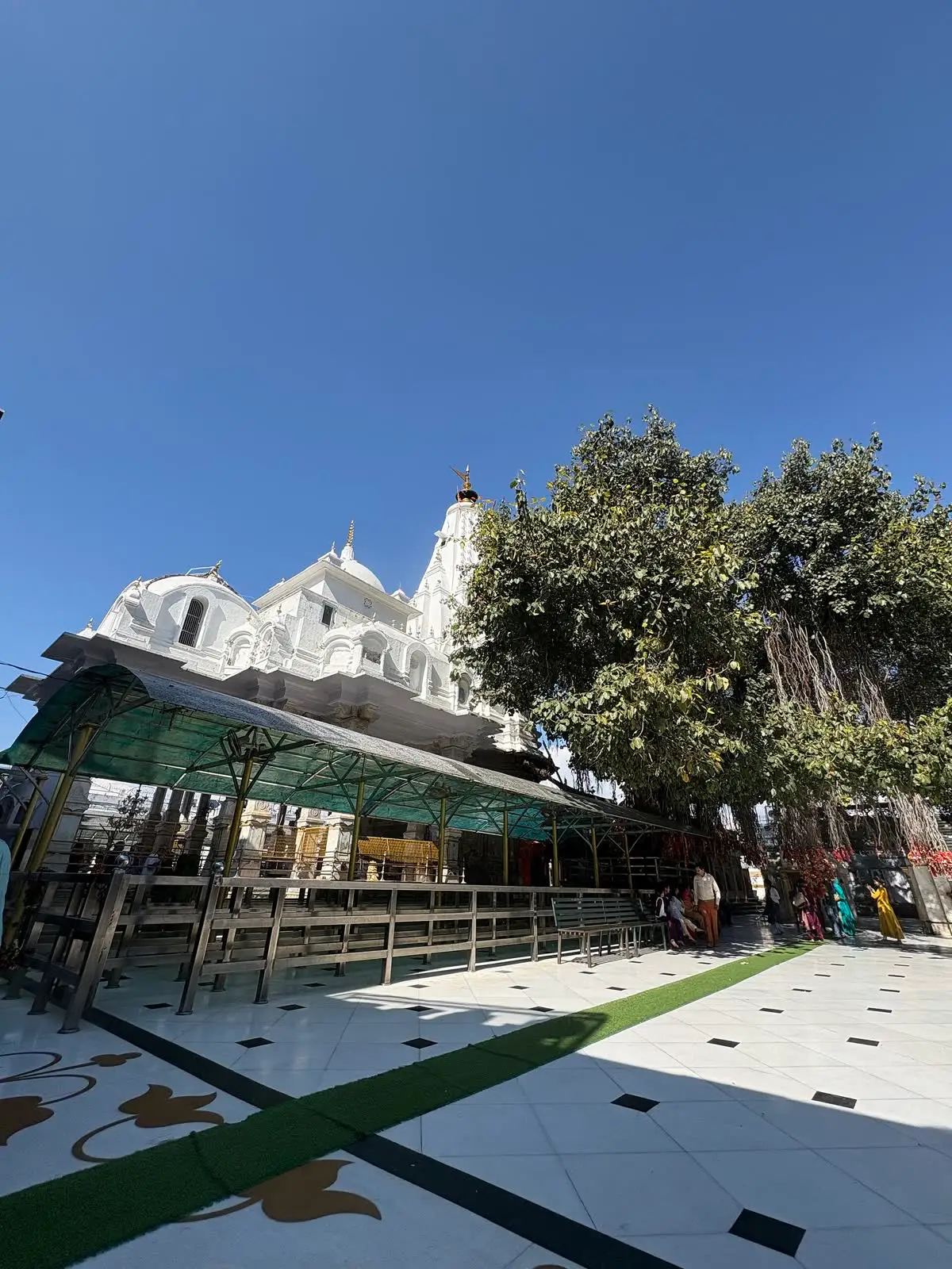 White temple compound of Brajeshwari Devi in Kangra seen across a paved open courtyard