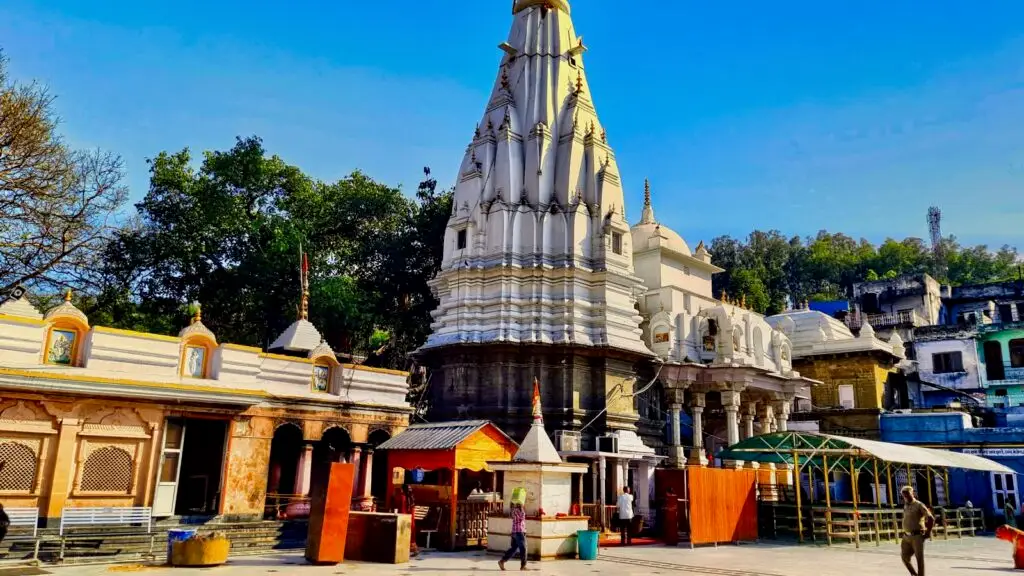White stone shikhara of Brajeshwari Devi temple rising above a paved courtyard in Kangra