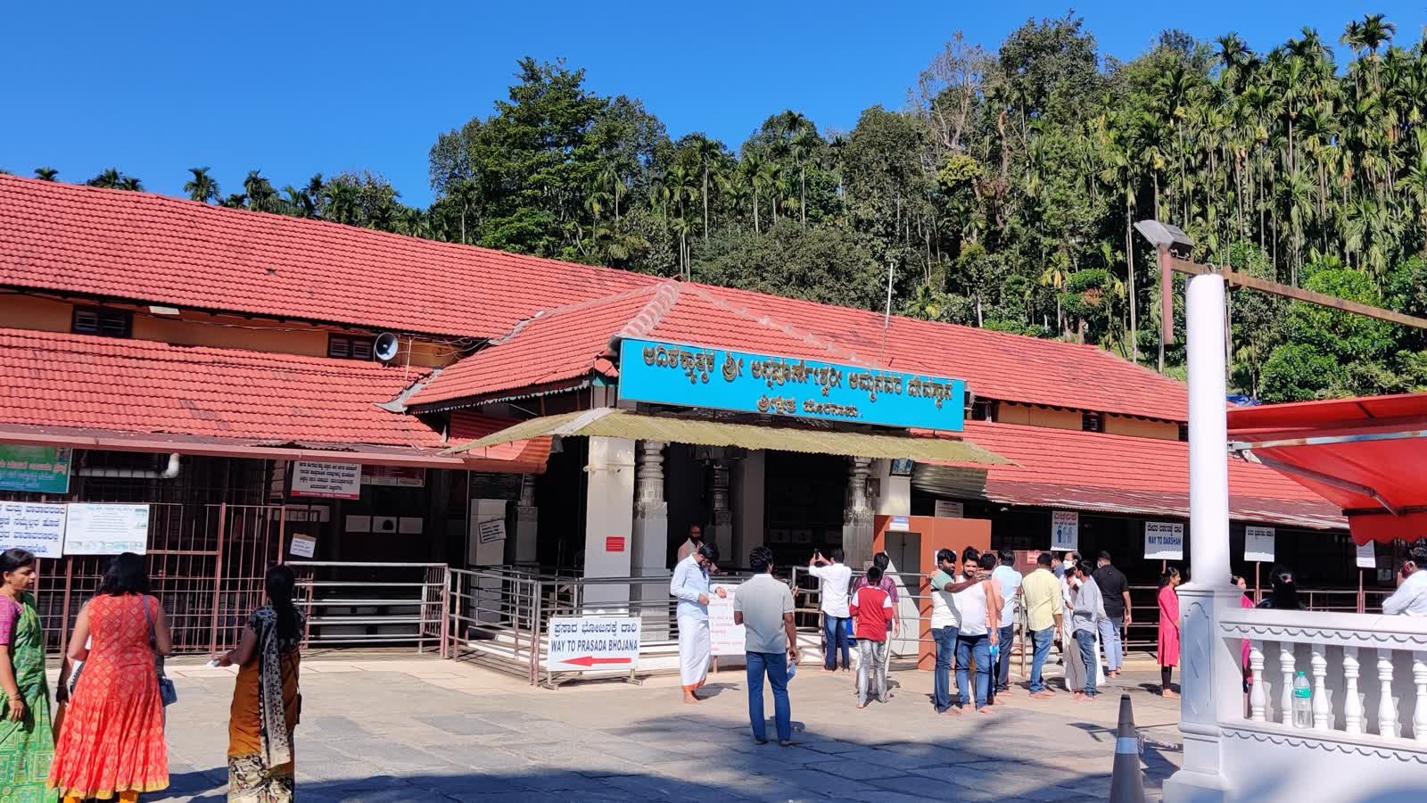 Front entrance hall of Sri Annapoorneshwari temple at Horanadu with devotees and areca palms behind