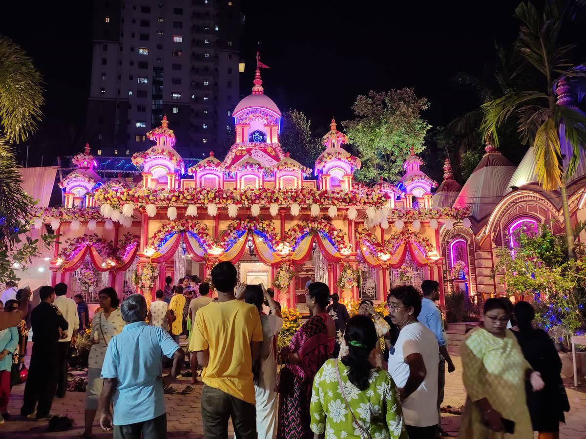 Crowds visiting a brightly lit Kali Puja pandal in Kolkata at night
