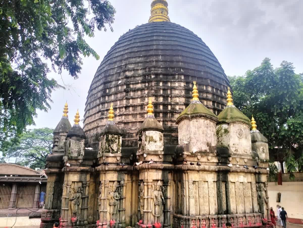 The main shikhara of Kamakhya Temple, showing the beehive dome above rows of carved stone panels and sculptures
