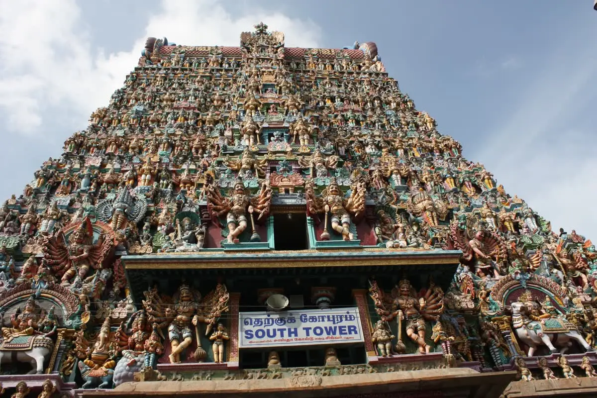 South gopuram of Meenakshi Amman temple covered in colourful stucco figures against the sky