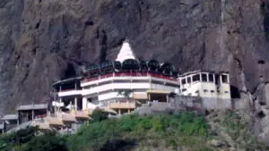 White Saptashrungi Devi temple complex built against a steep basalt cliff near Vani