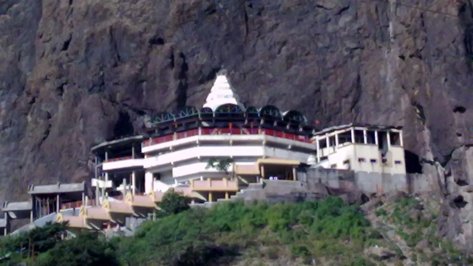 White Saptashrungi Devi temple complex built against a steep basalt cliff near Vani